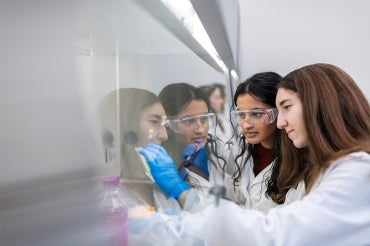 Two students work under a fume hood at a U of T lab