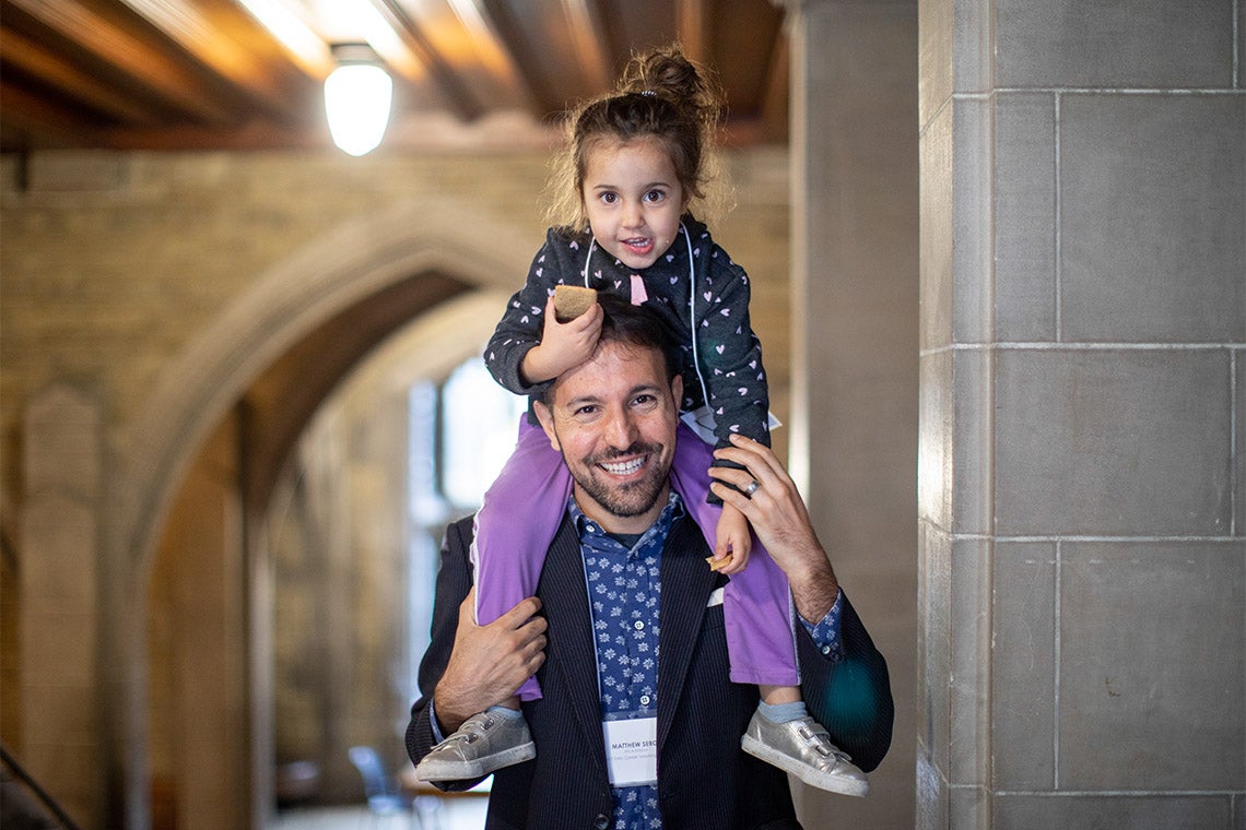 Portrait of Matthew Sergi with daughter Clio Glenn-Sergi on his shoulders