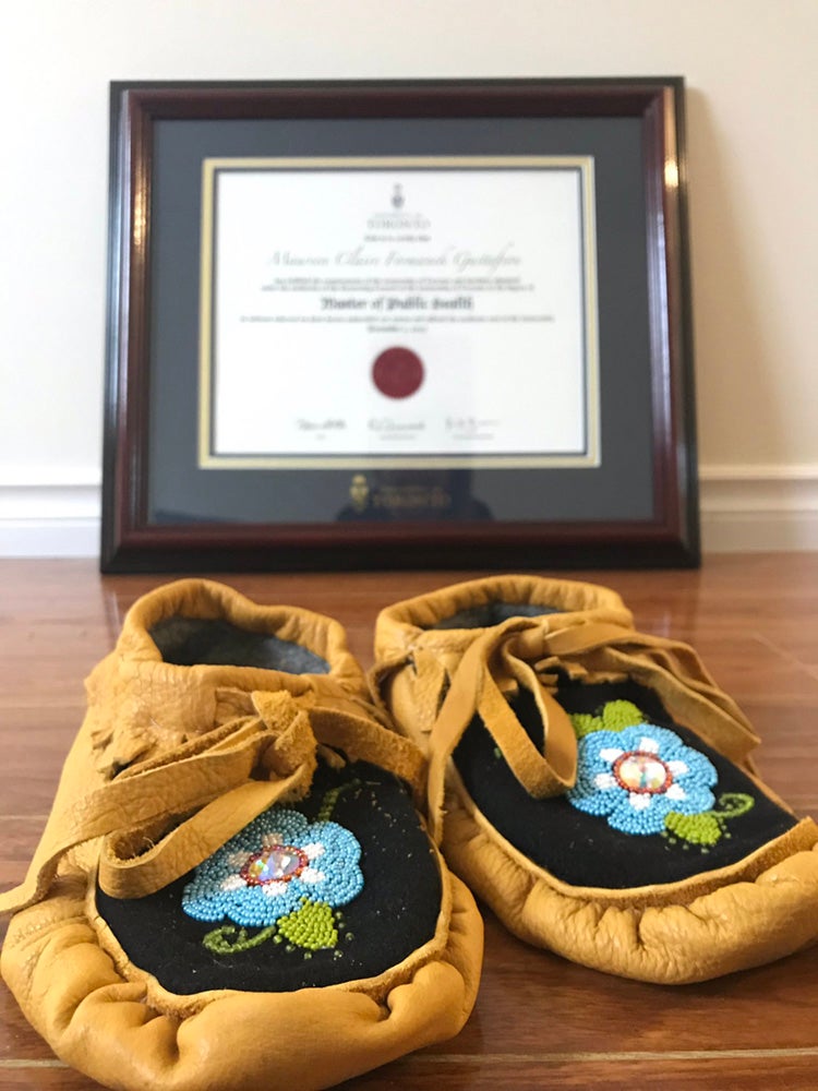 Gustafson's mother's moccasins sit in front of Gustafson's degree