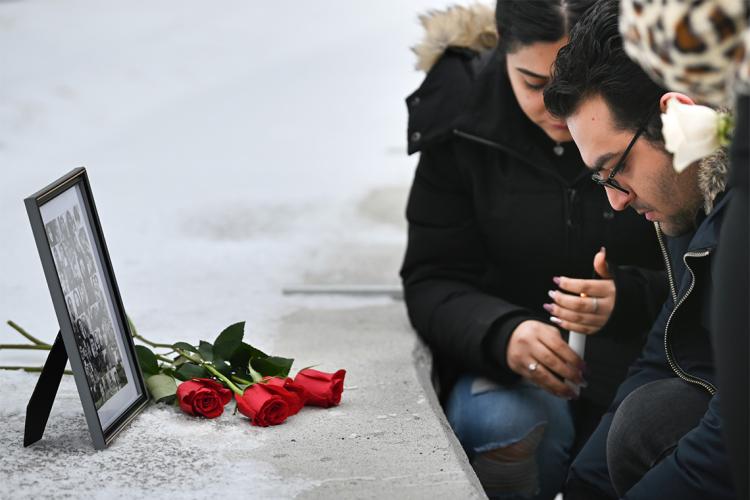 Two U of T students pay their respects in front of a photo of the victims of the plane crash at the U of T Scarborough vigil