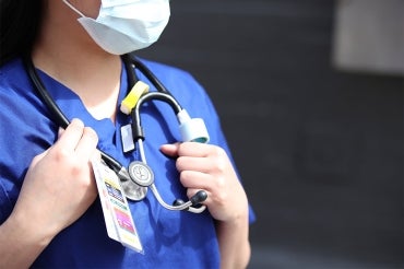Nurse wearing a mask and holding stethoscope