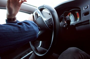 Photo of a driver turning a steering wheel suddenly