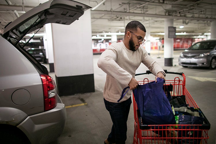 Photo of Nelson loading groceries into his car