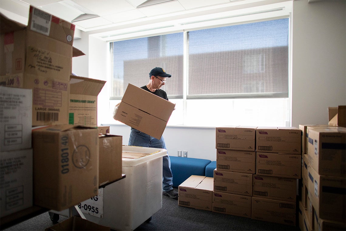 a worker sorts boxes of ppe at the university of toronto