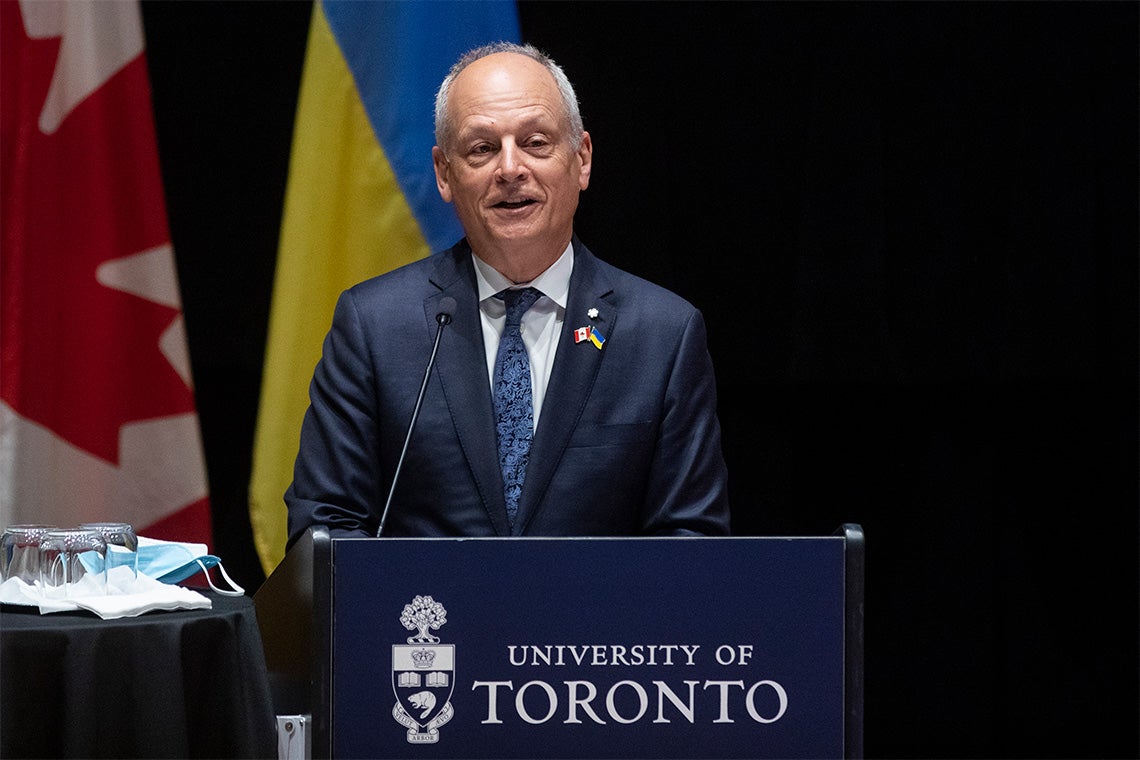 Meric Gertler stands at a podium