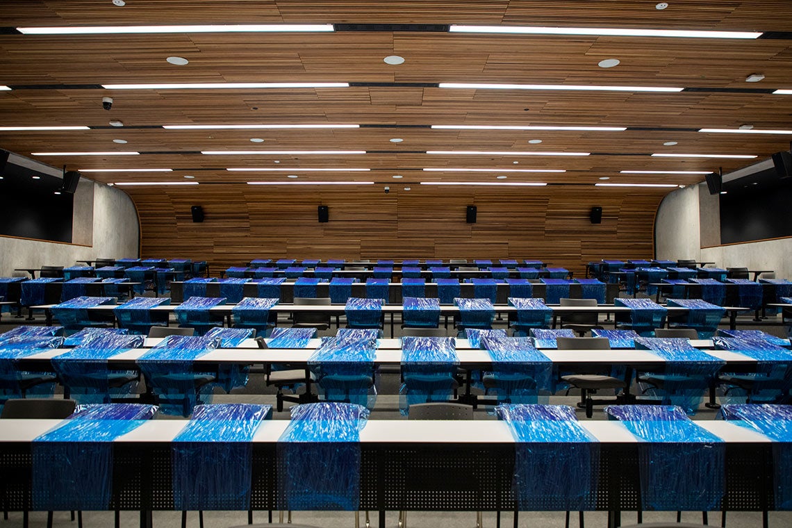 Shot of a lecture hall at U of T Mississauga with blue shrink wrap blocking off the majority of desks