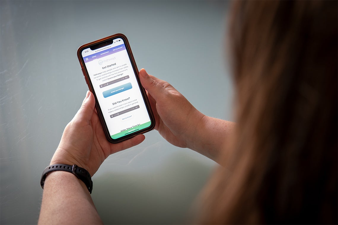 A woman looks at a support app on her phone
