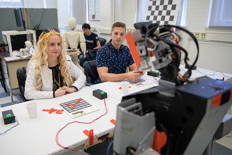 Goldie Nejat with a student and one of her robots