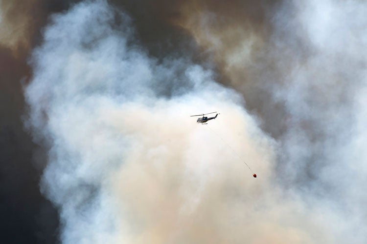 photo of helicopter carrying water to fire