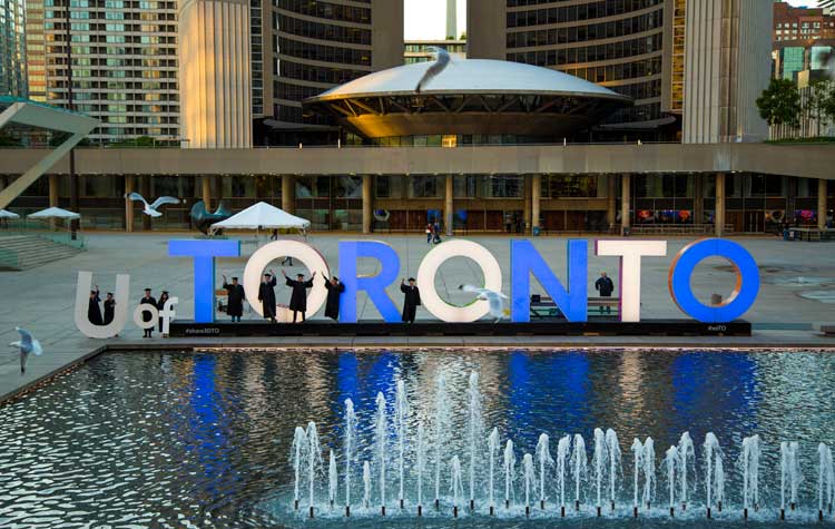 photo of Toronto sign with grads posing behind fountain