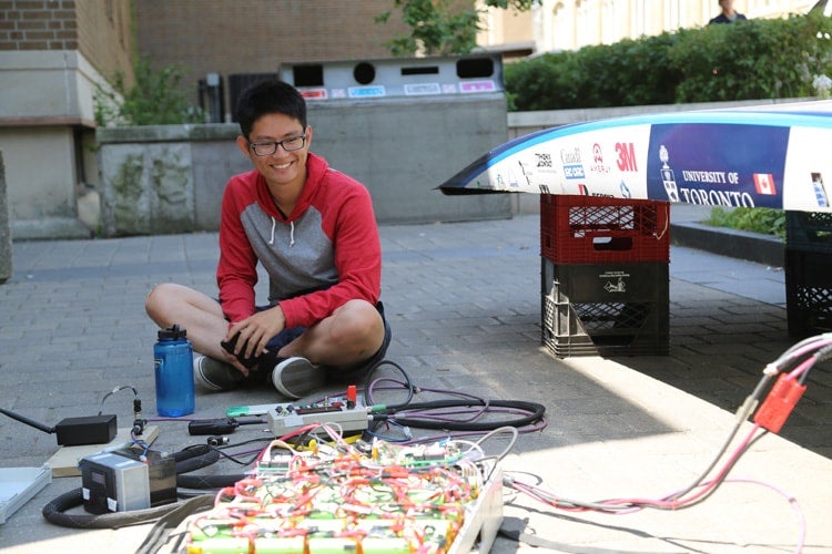 photo of student and partly assembled car