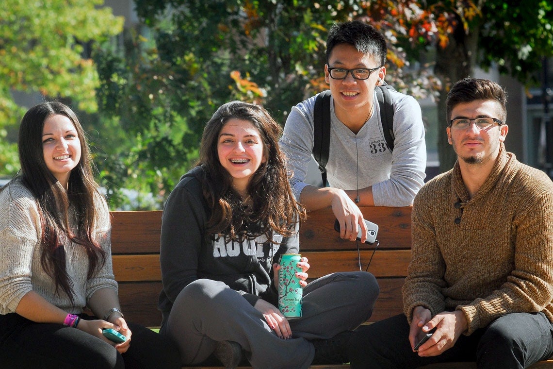 Photo of four students on bench