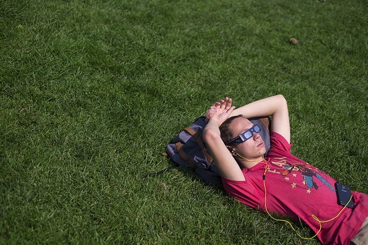 Student on the grass watching eclipse