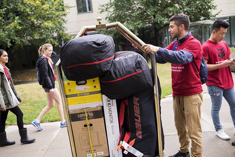 Justin Zelnicker pushing hotel cart outside Woodsworth College