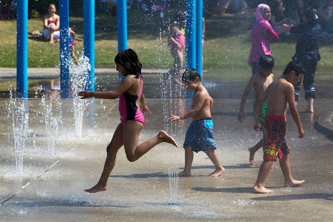 children playing in water fountain