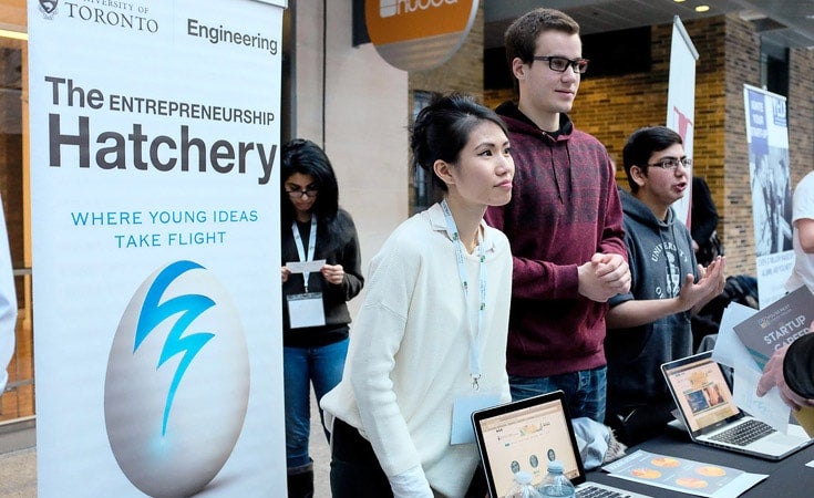 A group of students stand a table with a sign for the Hatchery.
