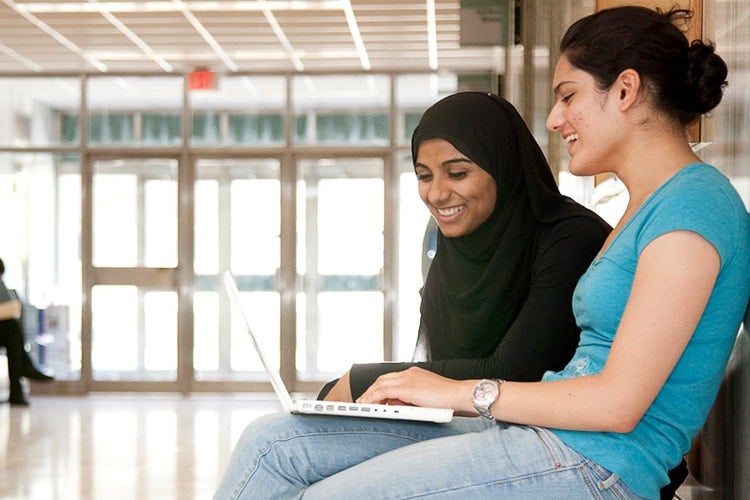 Two students looking at a laptop.