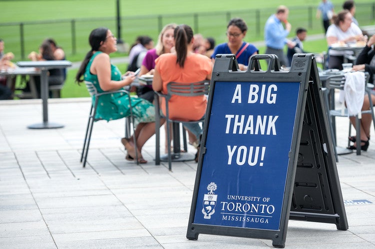 A sandwich board with the words "A big thank you," with people sitting in the background.