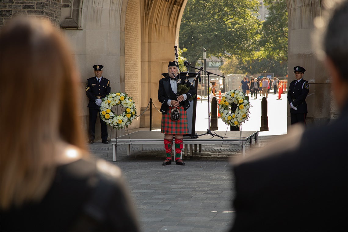 bagpiper is seen playing under the solders tower archway
