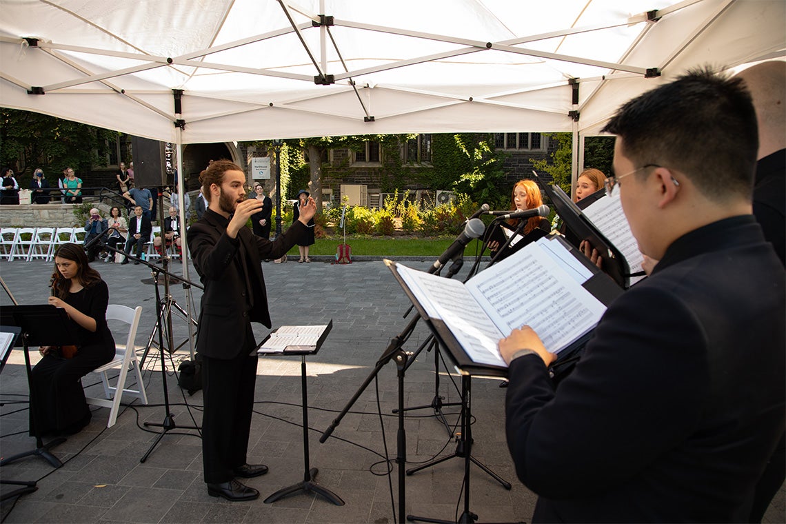 Conductor Michael Denomme leads the carolers