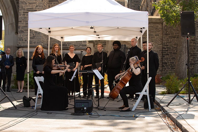 The choir stands by while the violin and cello are played