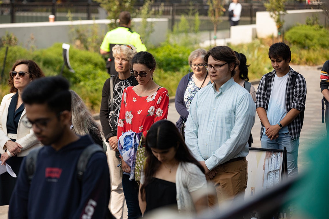 people of all backgrounds and ages are seen bowing their heads during the moment of silence for Queen Elizabeth II