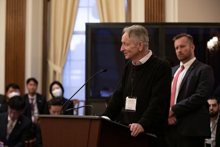 Geoffrey Hinton speaks at the podium at Simcoe Hall