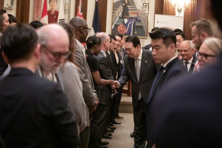 President Yoon Suk-yeol shakes hands with guests inside Simcoe Hall