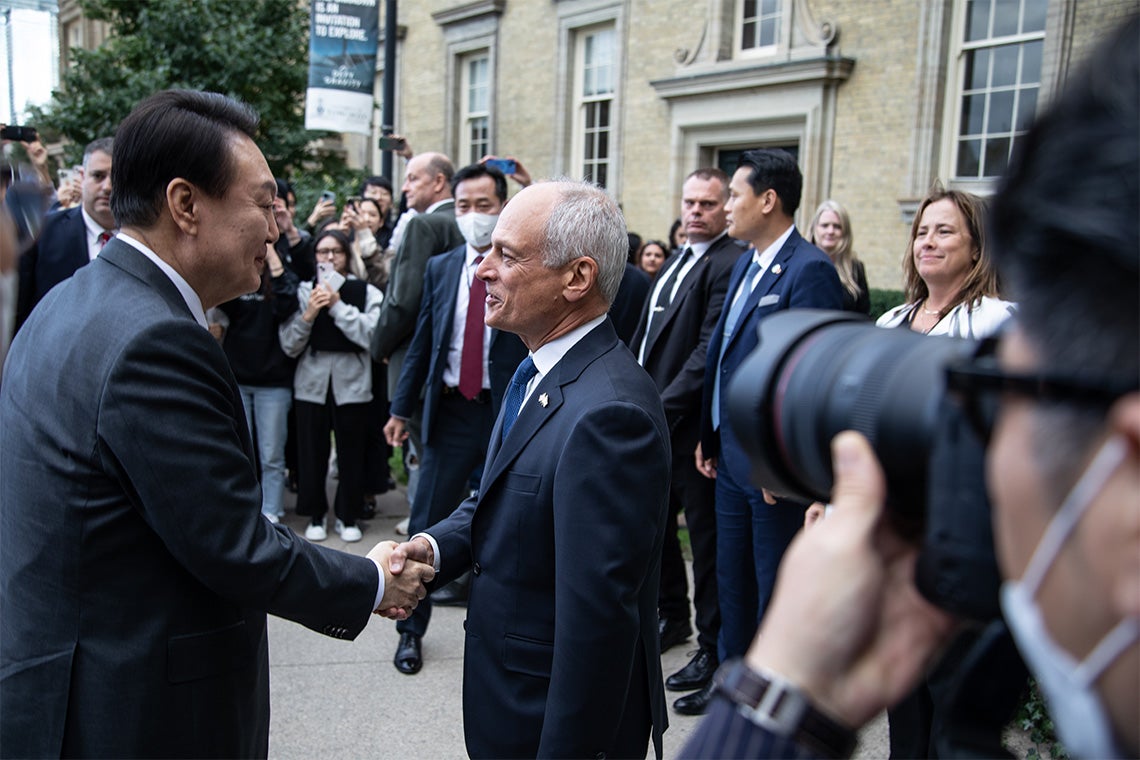 South Korean president Yoon Suk-yeol shakes hands with U of T President Meric Gertler outside of Simcoe Hall at the University of Toronto, St. George campus