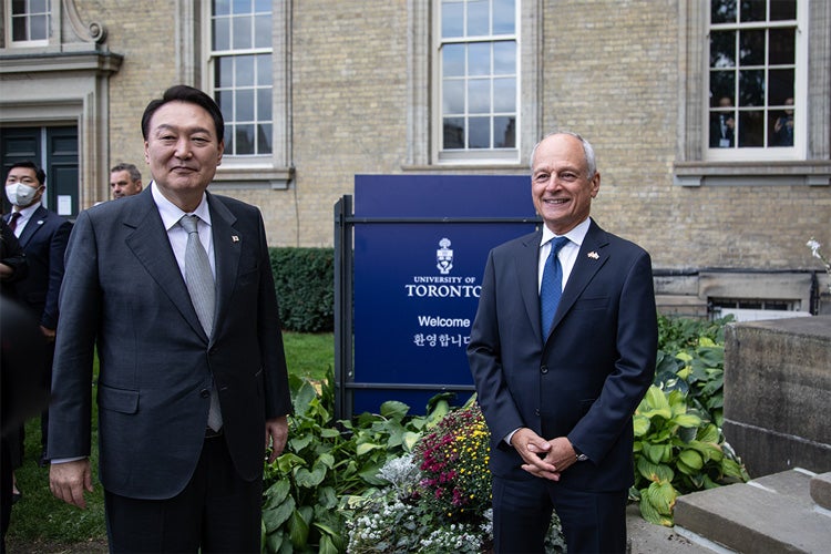 South Korean President Yoon Suk-yeol and U of T President Meric Gertler stand in front of a sign welcoming the South Koreans in South Korean text at Simcoe Hall
