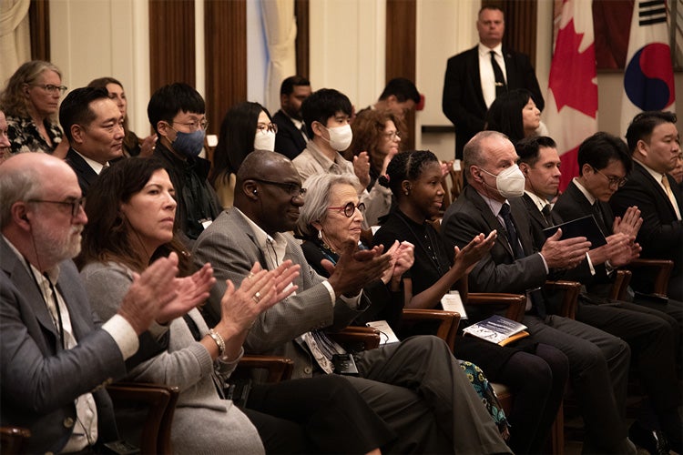 Guests including Scott Mabury, Kelly Hannah Moffat and Wisdom Tettey applaud following remarks by Geoffrey Hinton