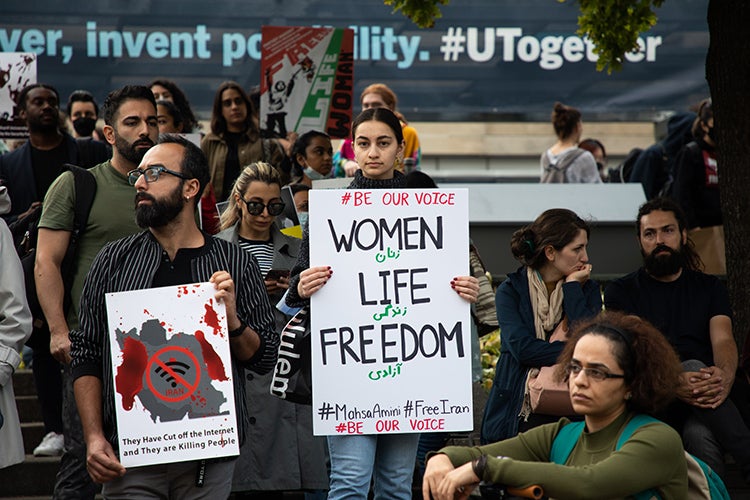 Protestors hold signs at a rally on the St. George campus