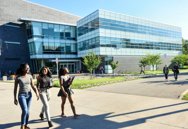 Three women walking outside on the UTM campus.