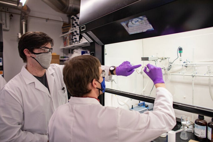 Two researchers working on a whiteboard.