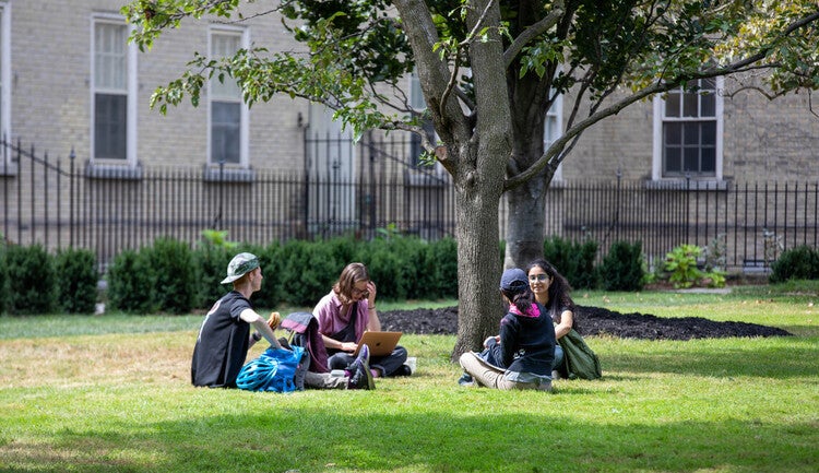 Students sitting in a circle in a quad.
