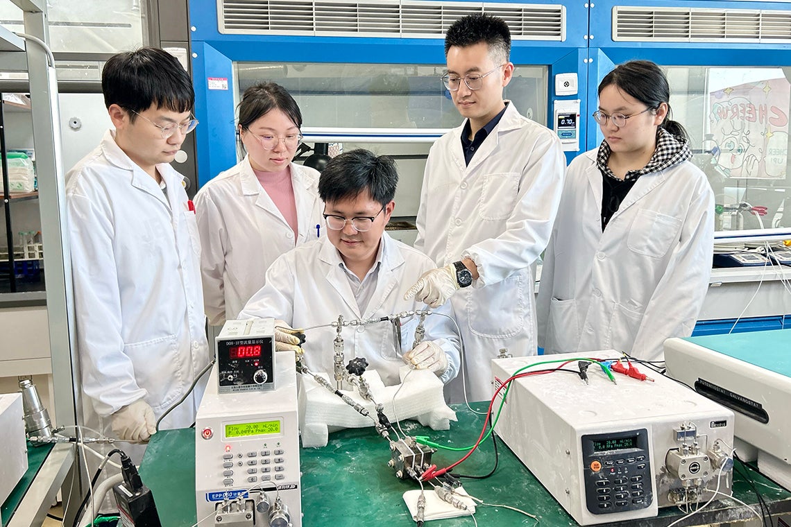 Huazhong University of Science and Technology researchers gather around an electrolyzer