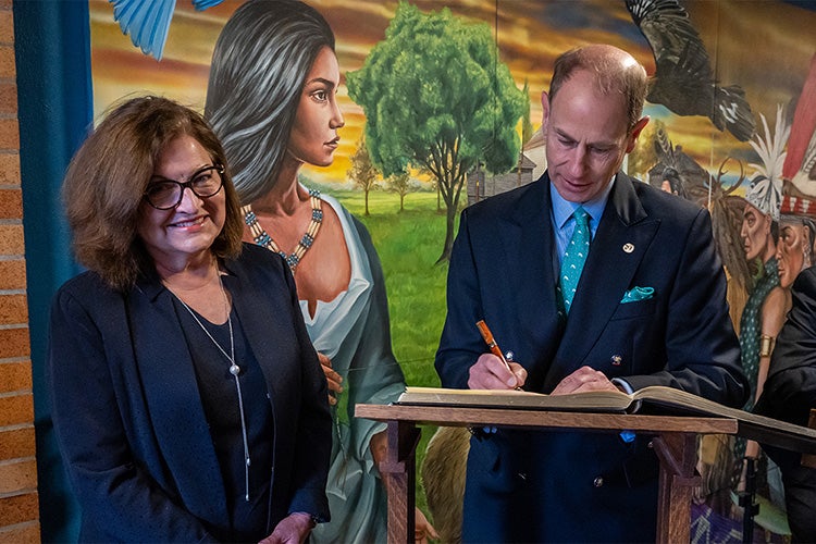 Anna Kennedy looks on as Prince Edward signs the U of T Distinguished Visitors’ Guest Book