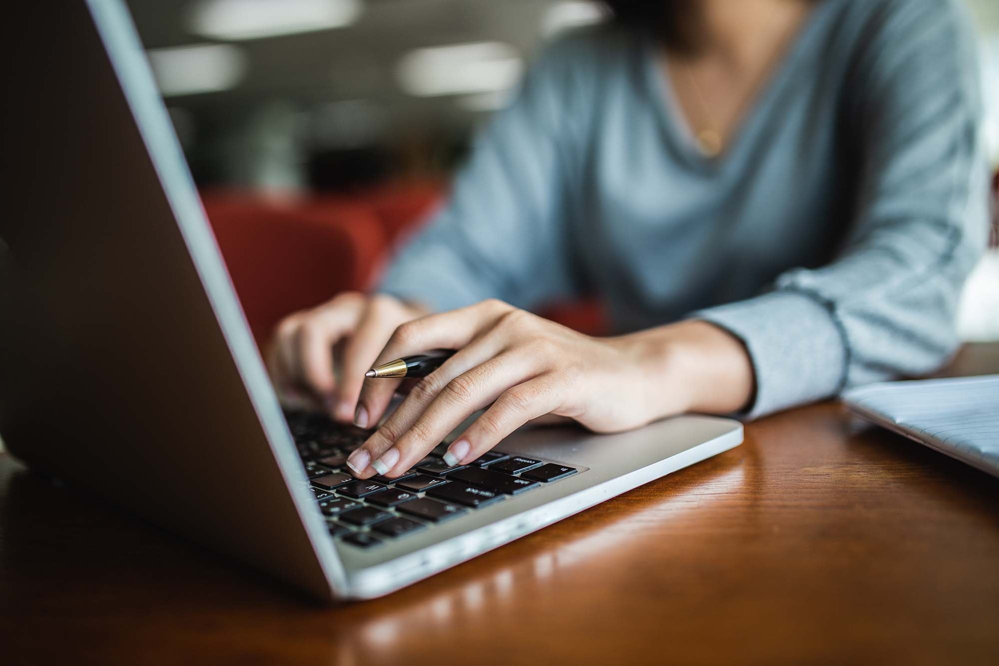 Woman typing on laptop keyboard