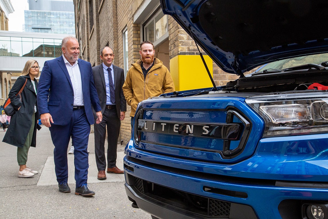 Ontario Energy Minister Todd Smith (second from left) walks toward a prototype electric vehicle created by a partnership between Litens and the University of Toronto's Electric Vehicle Research Centre, led by Professor Olivier Trescases (ECE, second from right. Geoffrey Ryeland, Director, Electromotive Engineering at Litens is seen at right. (Photo: Aaron Demeter)