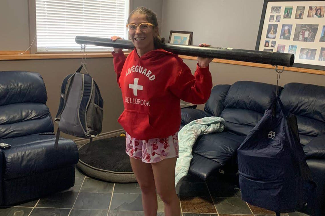 Brenna Hamel weightlifting at home using a pipe and backpacks