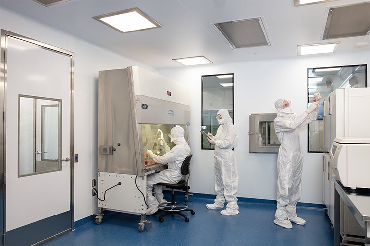 Workers demostrate the new CCRM lab in clean suits