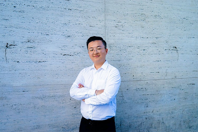 Portrait of Richard Cao in front of a grey wall 