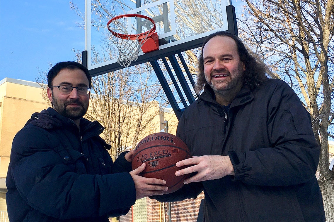 Daniel and Jeffrey Rosenthal hold a basketball together outside