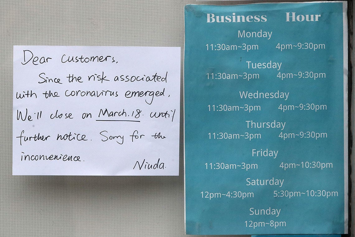 A sign reads: Dear customer, since the risk associated with the coronavirus emerged we'll close on march 18 until further notice. Sorry for the inconvenience. niuda