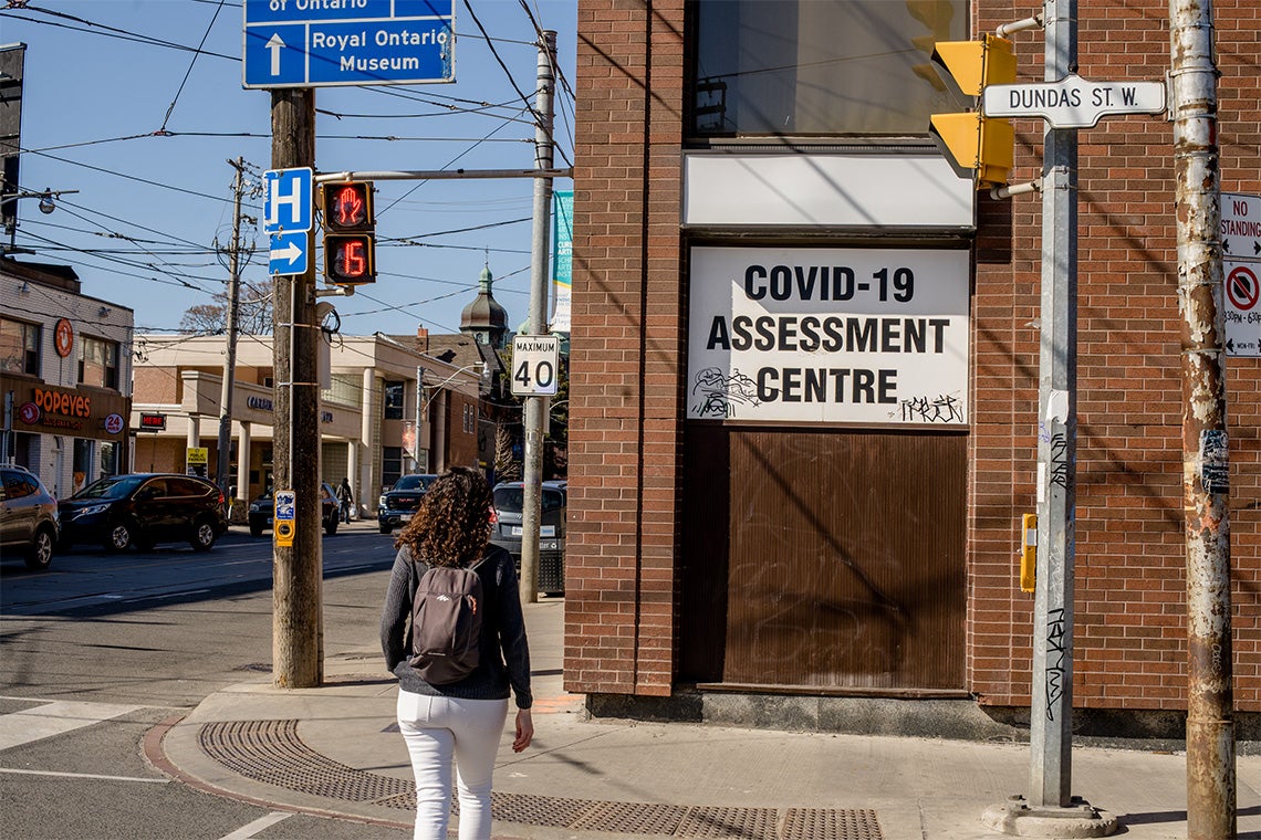 a woman walks past a Toronto COVID-19 assessment centre
