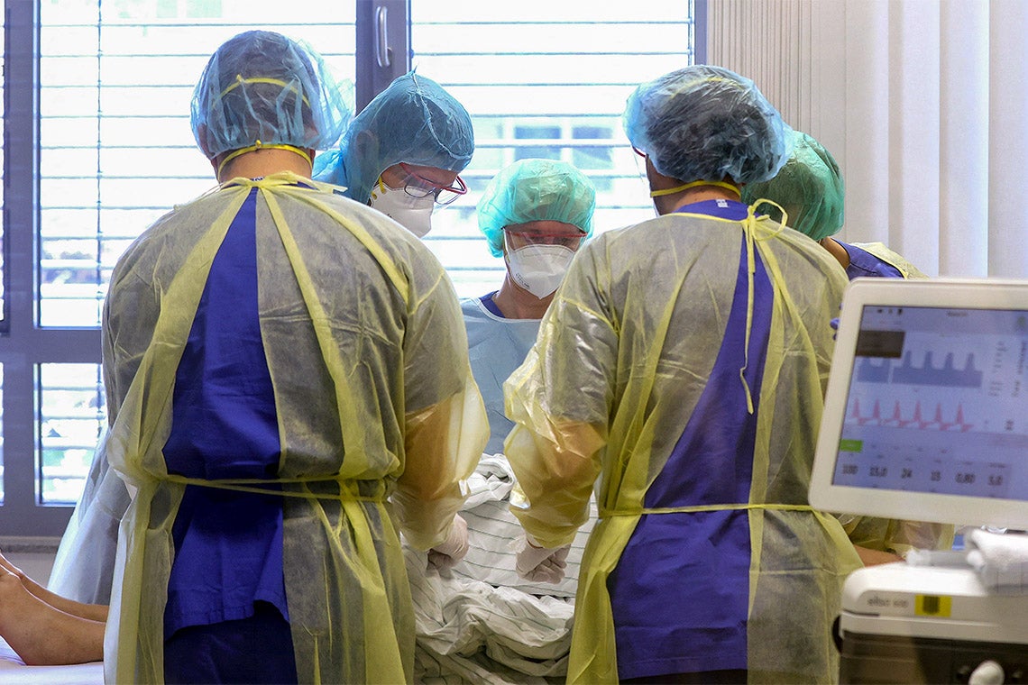 Several doctors attend to a patient with covid