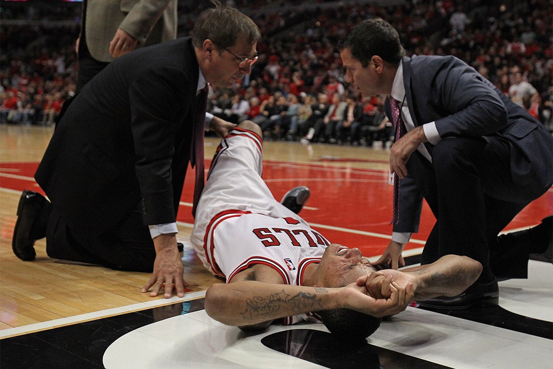an injured derrick rose is attended to by medics on the basketball court