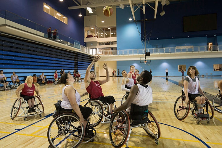 athletes in wheelchairs play a practice game of basketball at the pan am sports centre