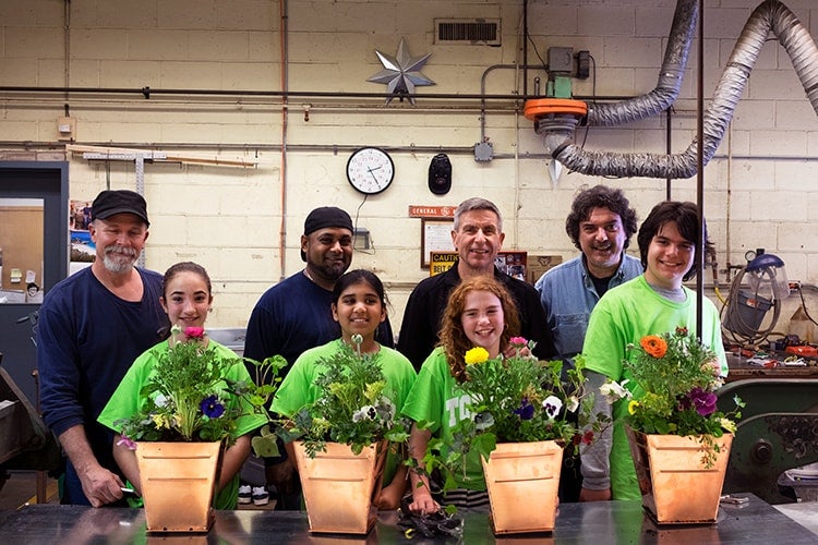 A group photo of parents and kids at a tinsmithing workshop at U of T