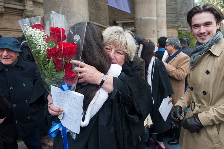 Family hugging outside Convocation Hall